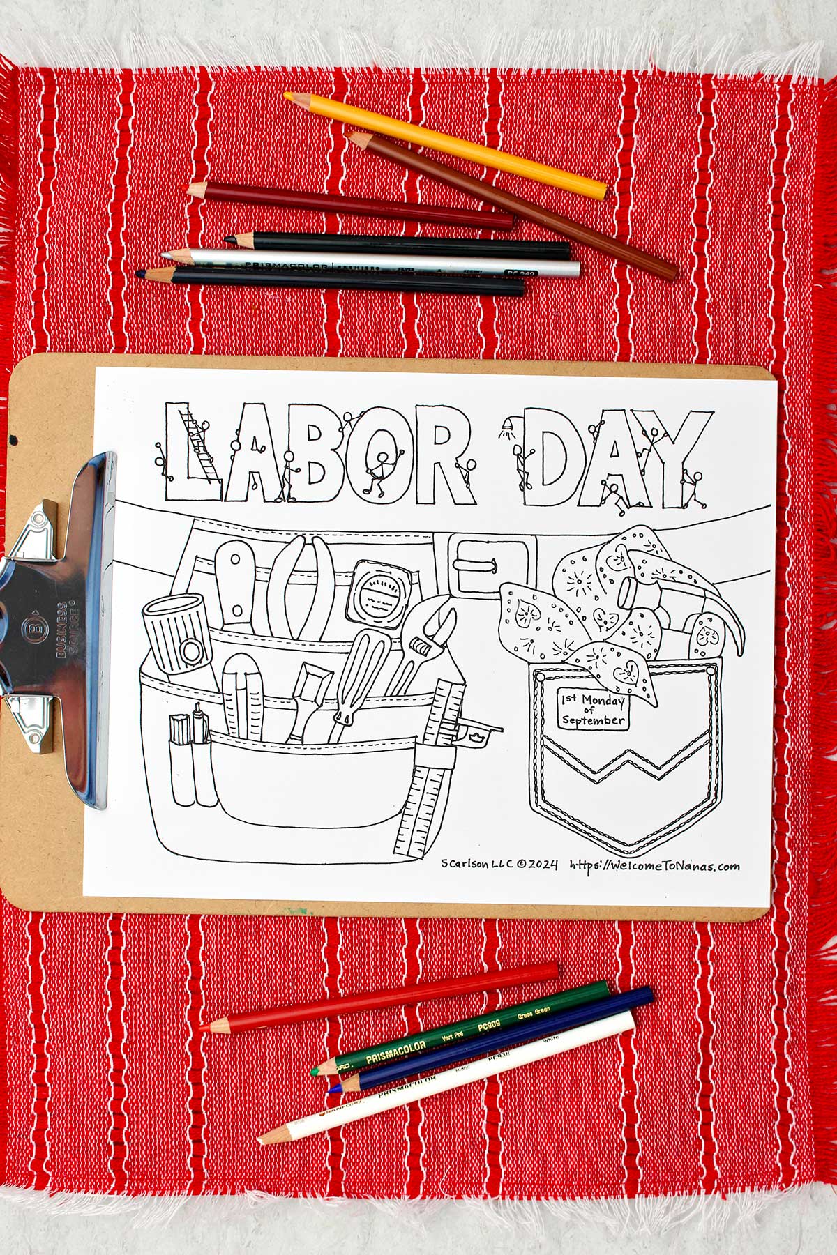 Labor Day coloring page of a tool belt filled with tools and a pocked with hammer and handkerchief clipped into a clip board resting on a red placemat.