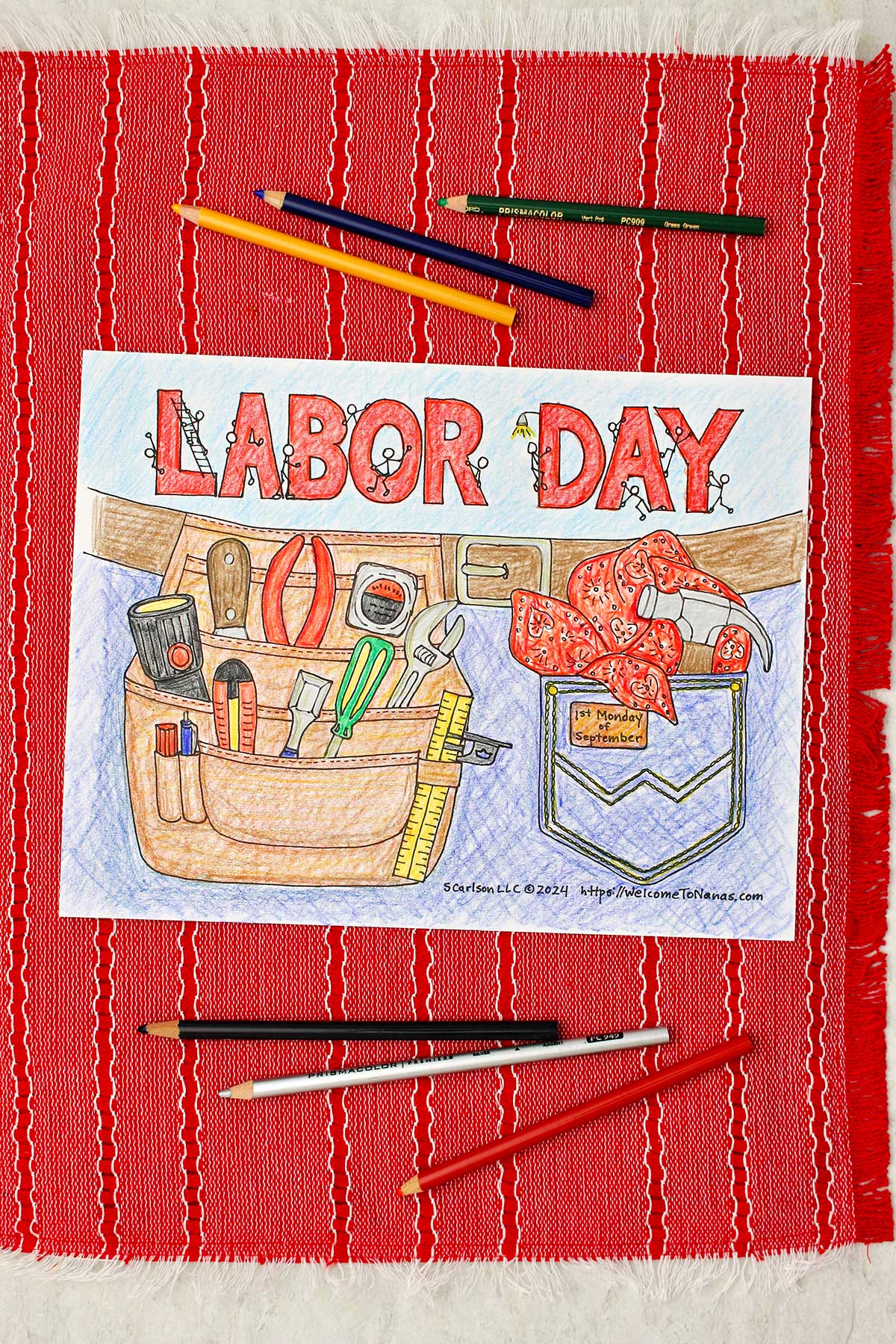 Completed Labor Day coloring page of a tool belt filled with tools and a pocked with hammer and handkerchief clipped into a clip board resting on a red placemat.