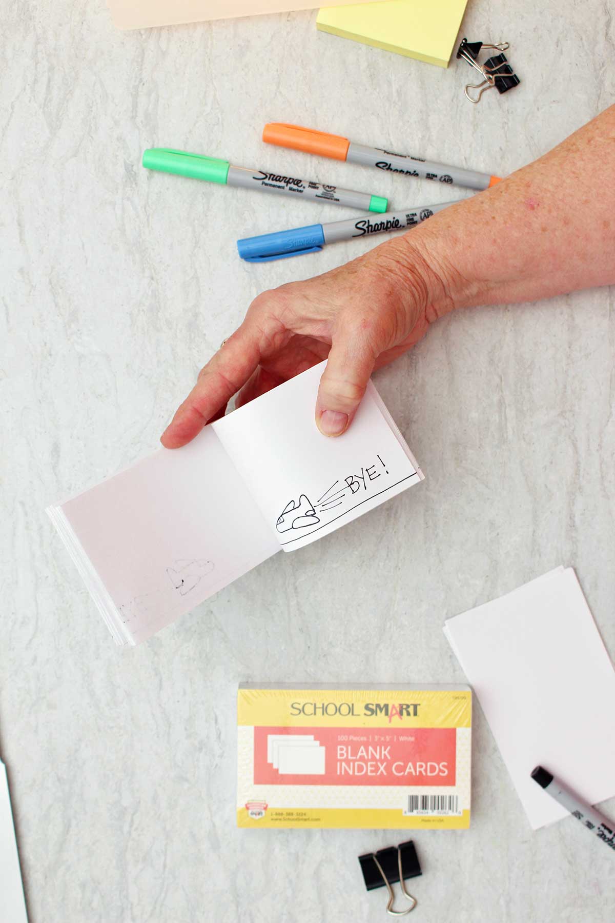 Person holding a flip book showing the last page of an airplane and the word "bye!"