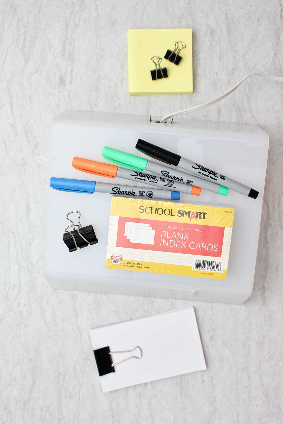 Supplies to make a flip book with idex cards. Colorful sharpies, binder clips, index cards, and a light box.