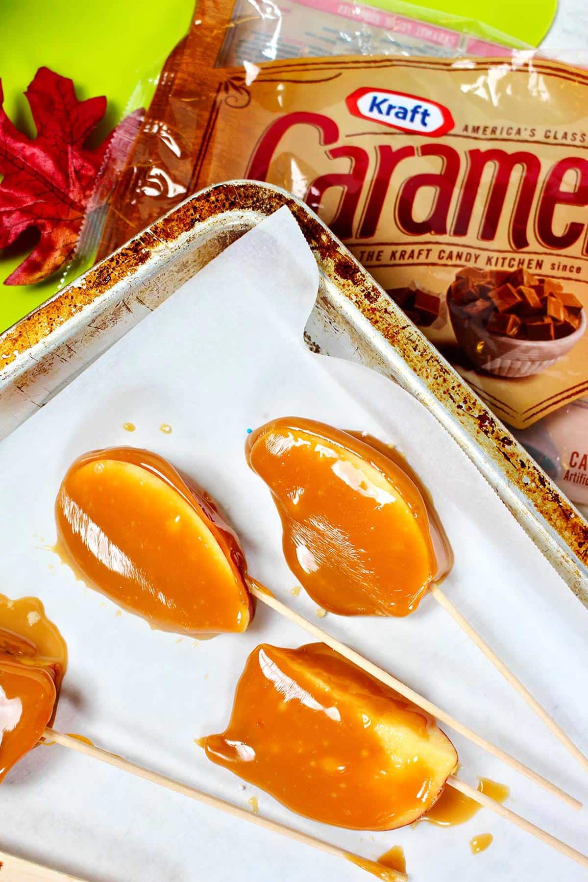 Caramel apple slices on parchment on top of empty bag of Kraft Caramel Bites.