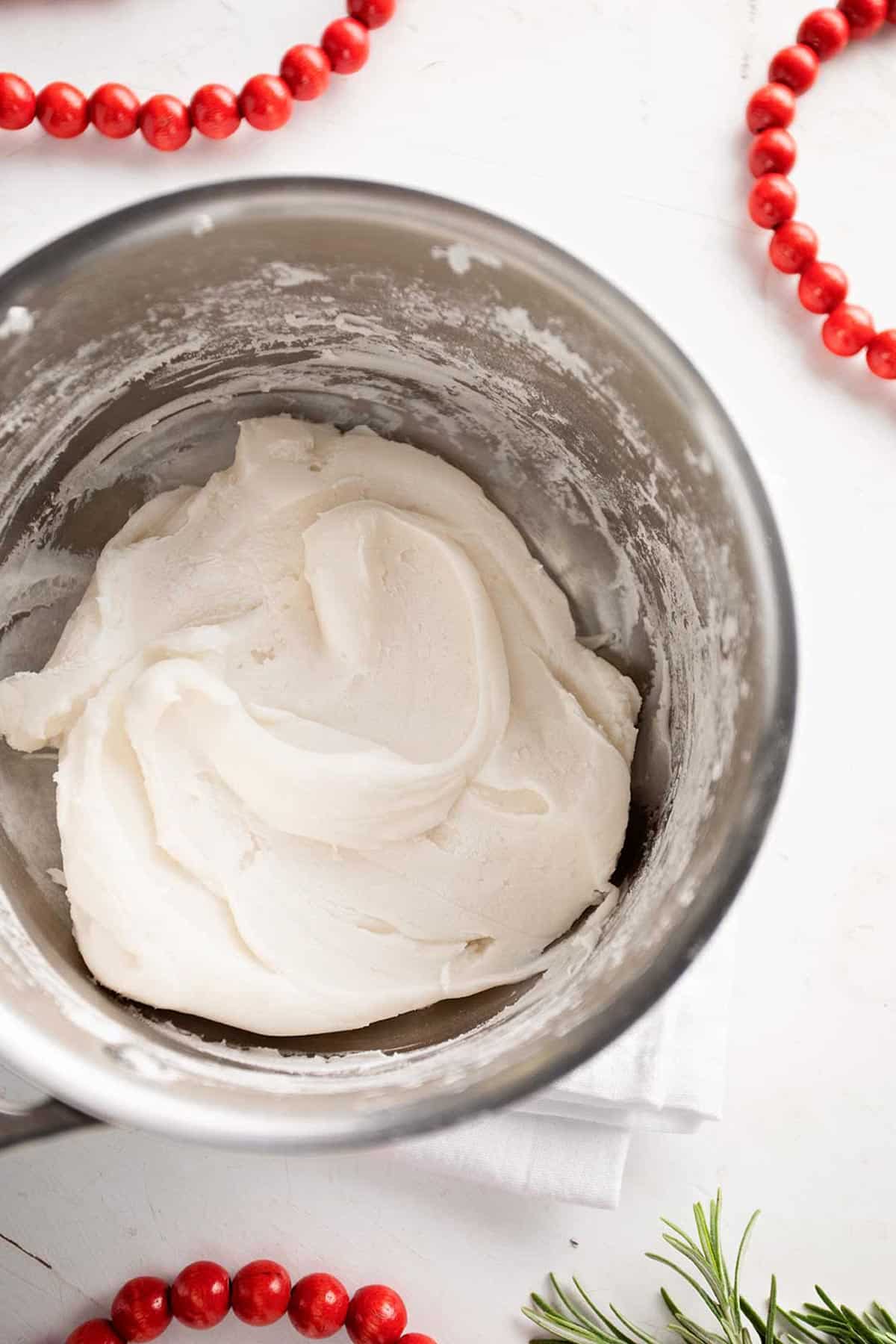 Pot of cornstarch dough with red wooden garland and greenery.