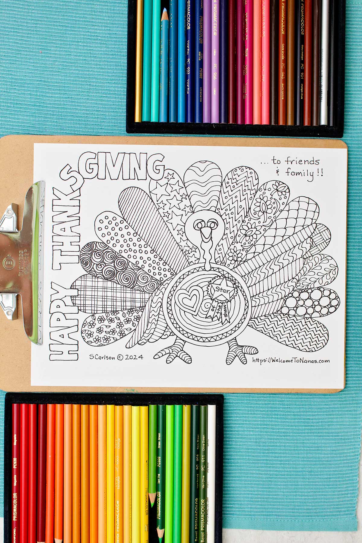 Uncolored Thanksgiving coloring page clipped into clipboard with two sets of colorful colored pencils near by.