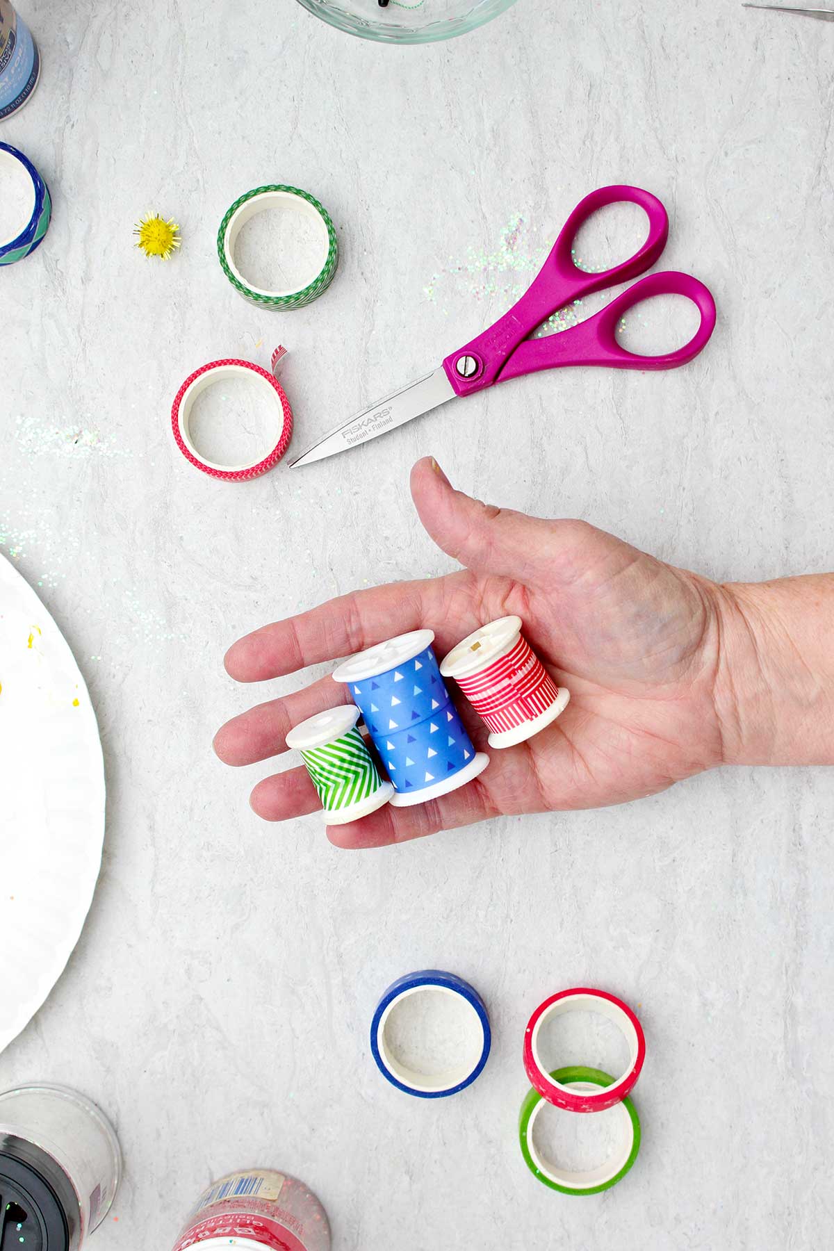 Three empty spools covered with colorful washi tape and ribbons