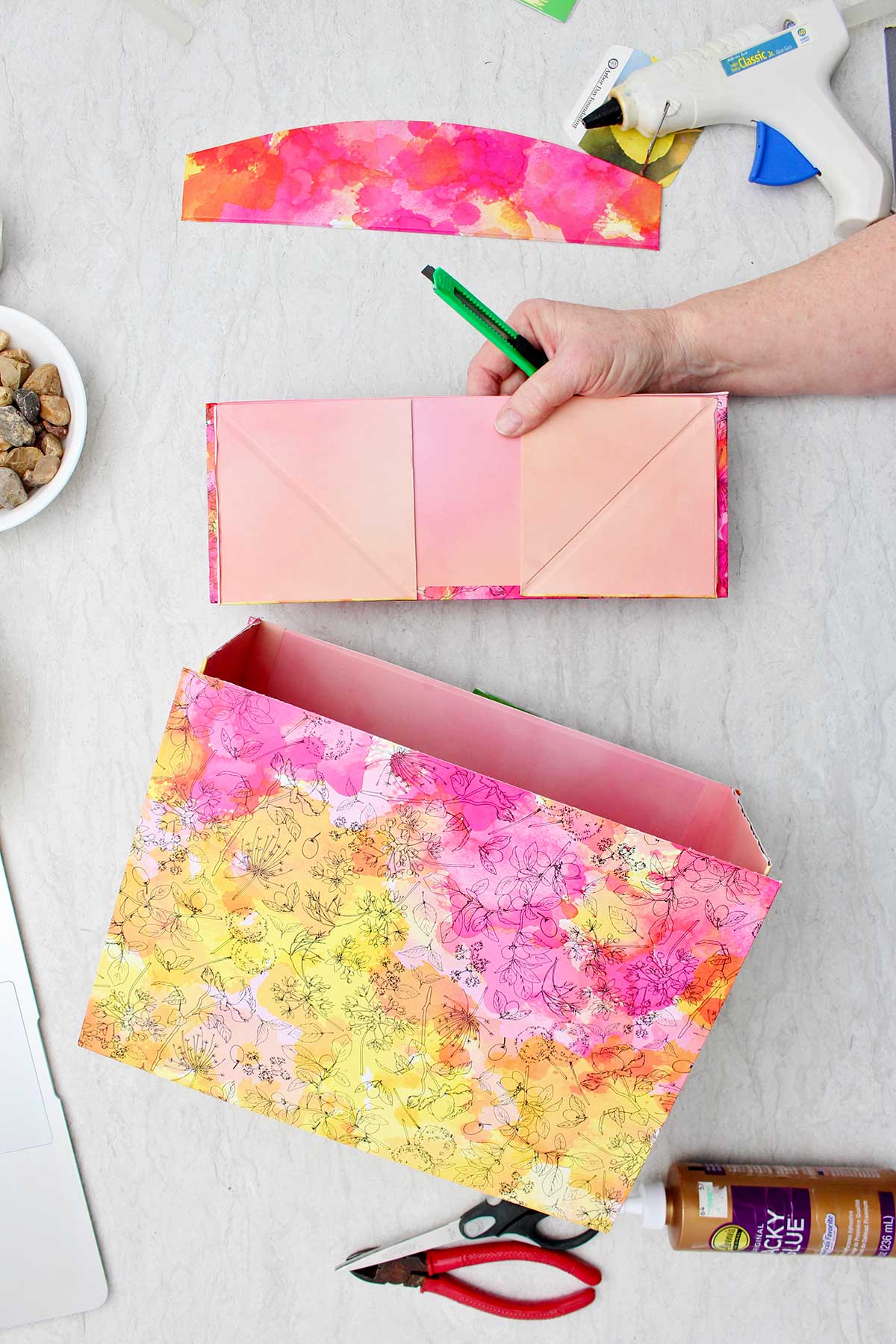 A person showing the removal of the bottom of a gift box to make the a book nook shelf insert.