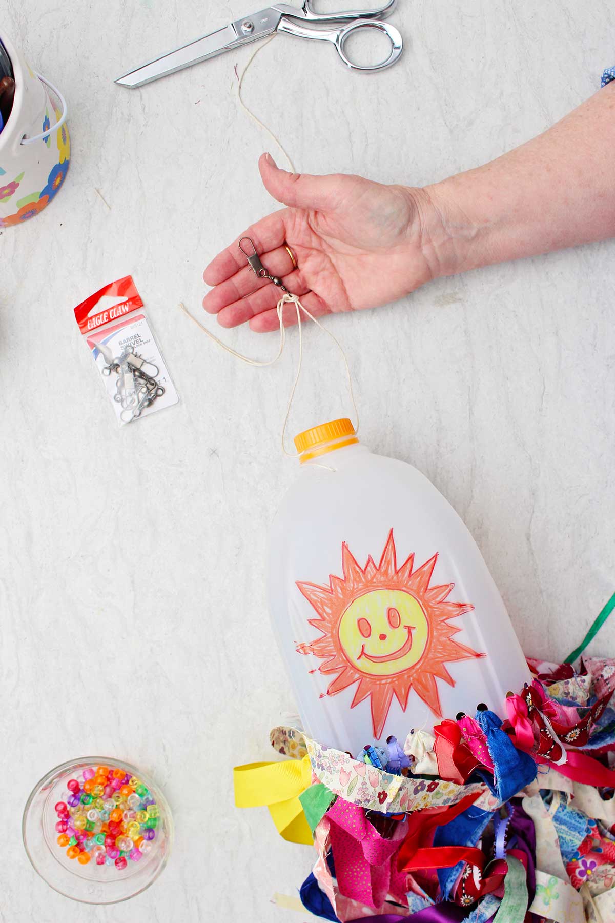Person showing the hook attachment to the top of the windsock for hanging purposes.