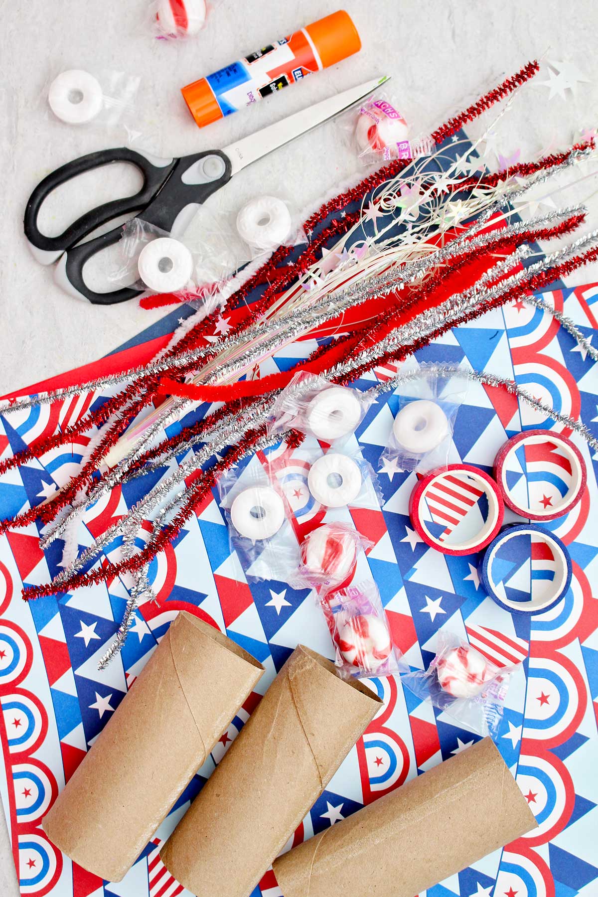 Sparkly pipe cleaners, red white and blue patterned scrapbook paper, red and blue washi tape, toilet paper rolls, scissors, glue and mints to put in the treat boxes.