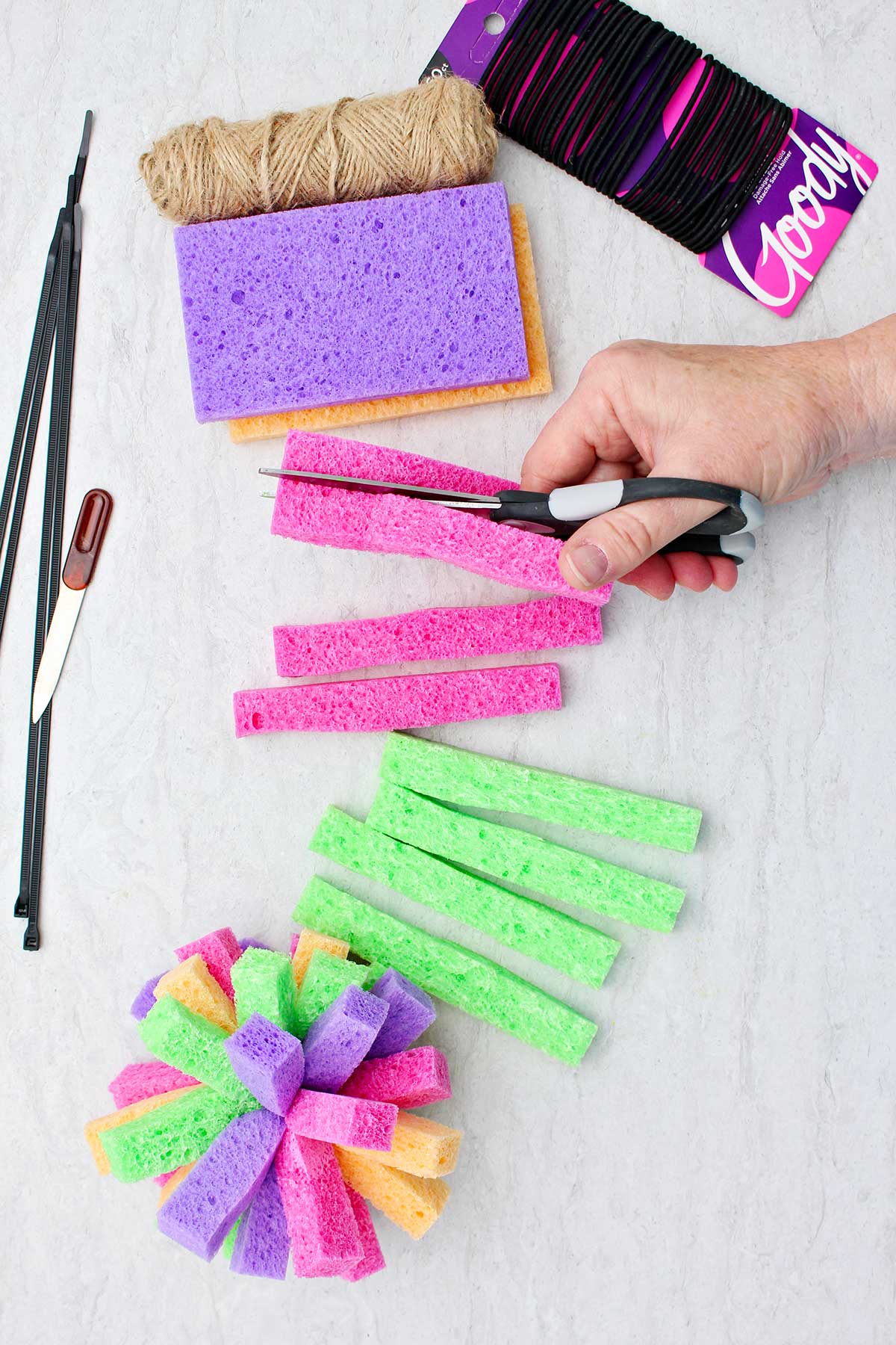 Person cutting multi colored sponges in long rectangular strips.