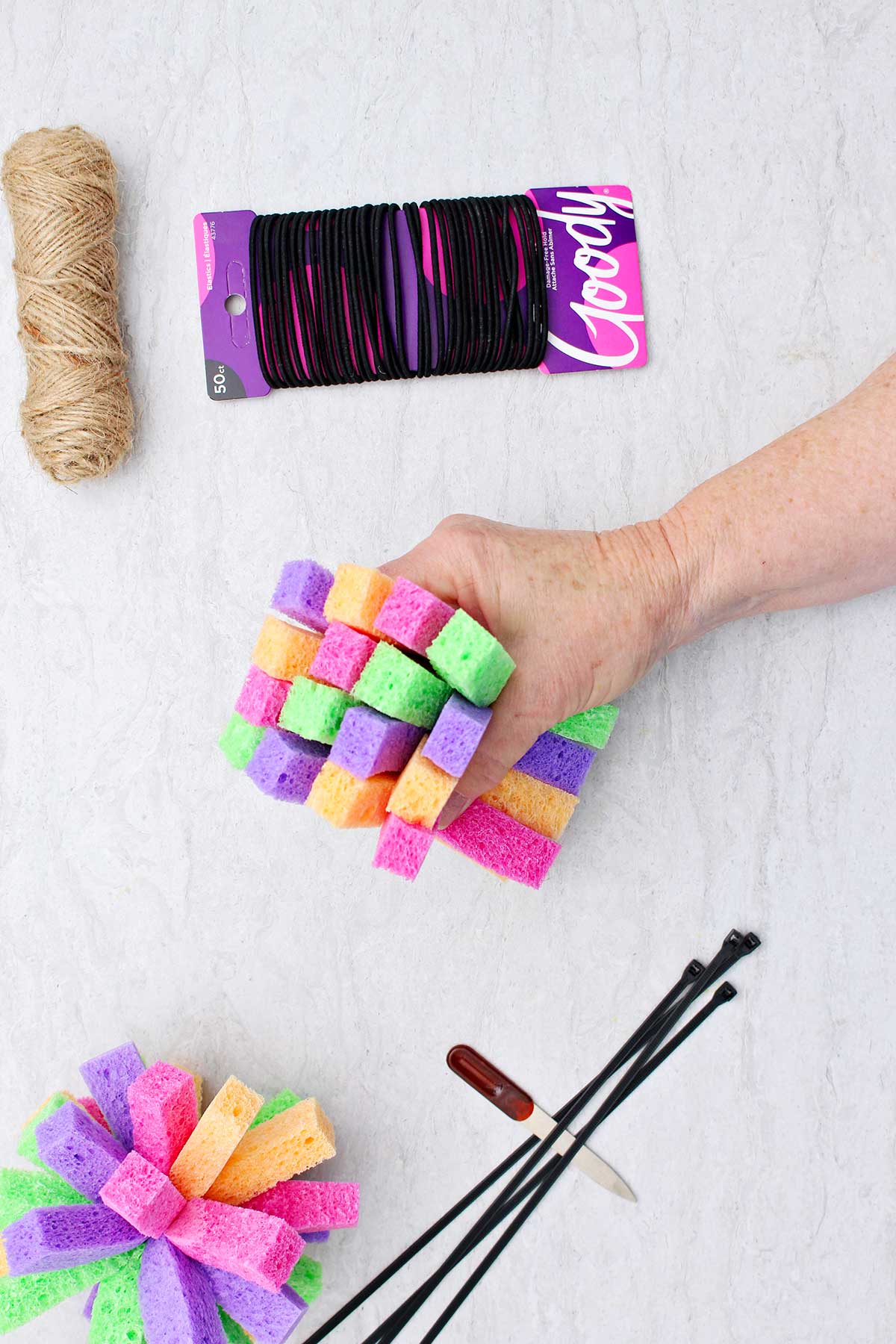 Person holding 16 long rectangular shaped sponge pieces together.