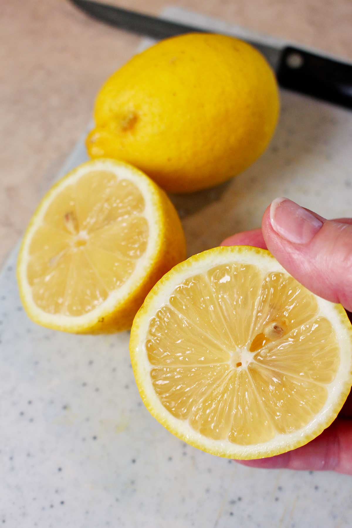 Person holding a halved lemon.