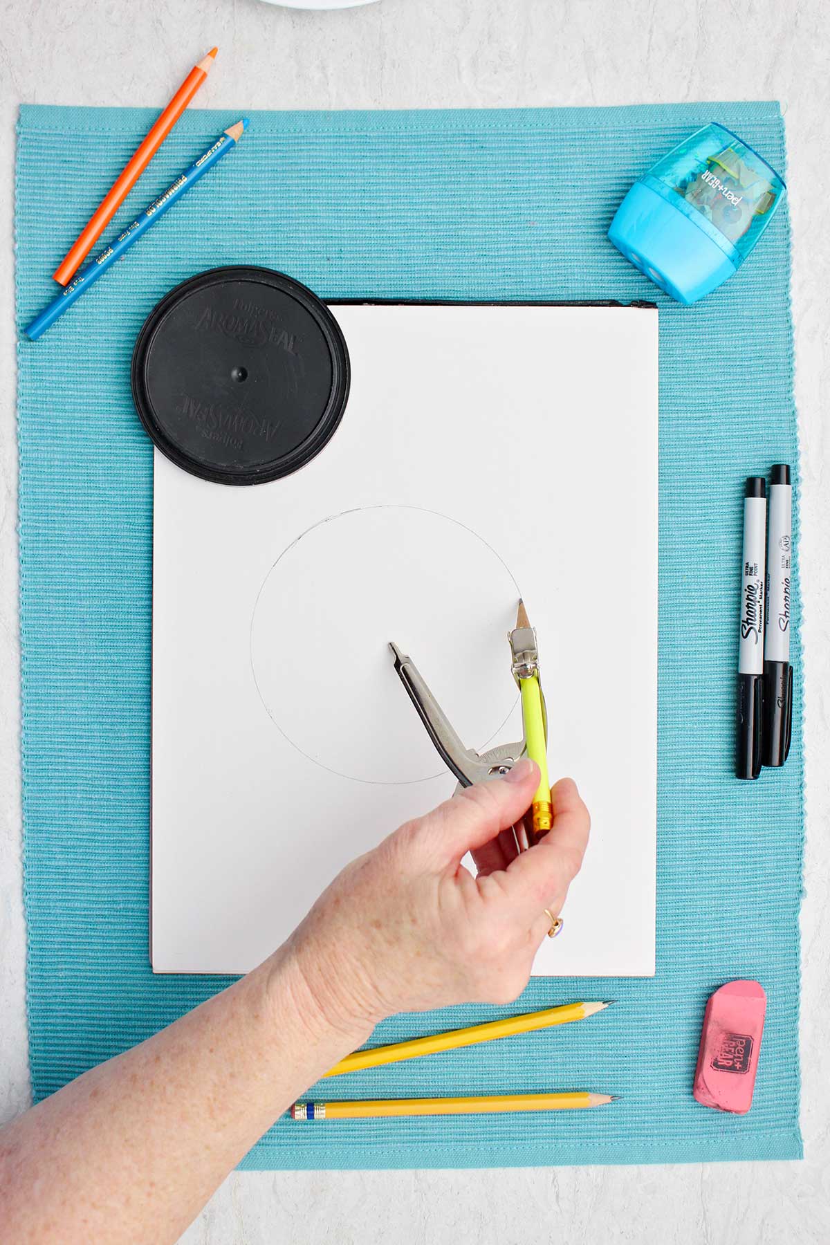 Person making a circle with a compass.
