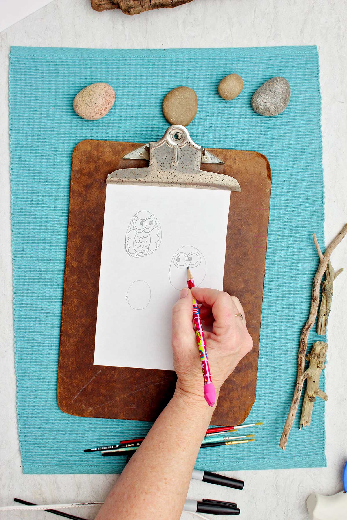 Person sketching out what they would like their owls to look like on a piece of scratch paper.