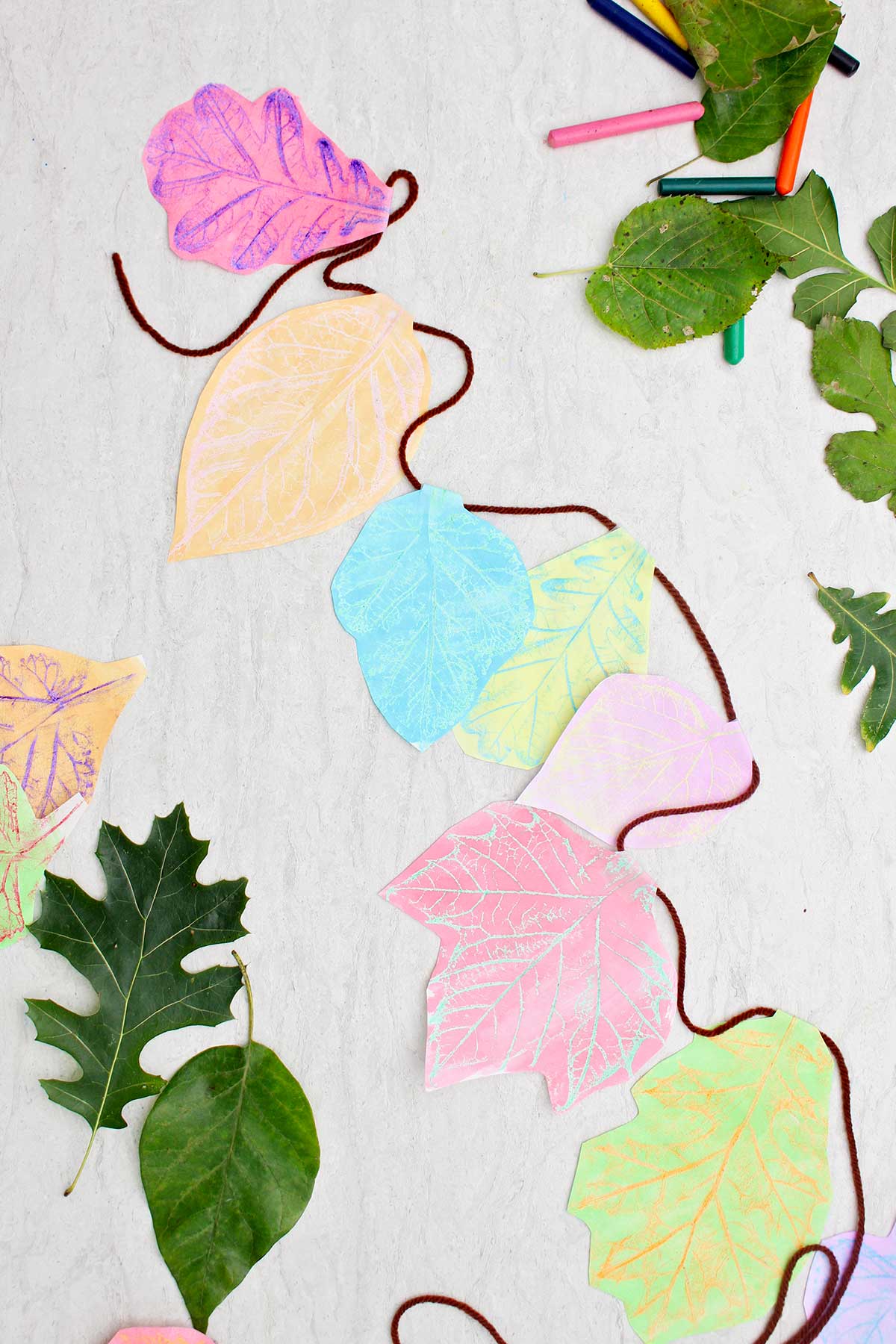 A leaf rubbing garland made from many colors of crayon and watercolor.