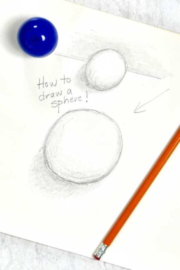 A tutorial pencil drawing of two 3-D spheres, sitting near a pencil and jar of drawing utensils.
