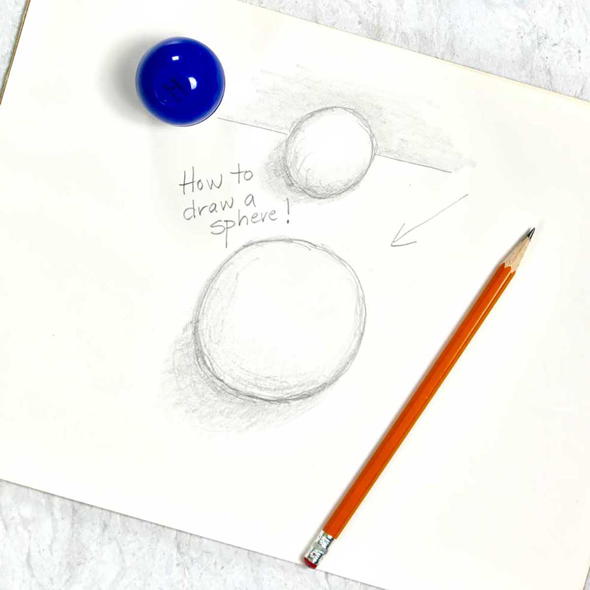 A tutorial pencil drawing of two 3-D spheres, sitting near a pencil and jar of drawing utensils.