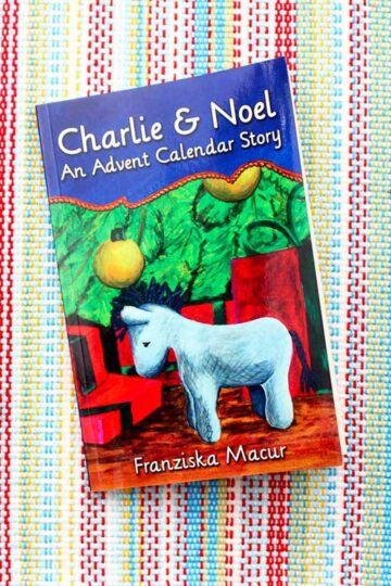 A book called "Charlie & Noel, An Advent Calendar Story" with a picture of a stuffed animal donkey and a Christmas tree on the cover.