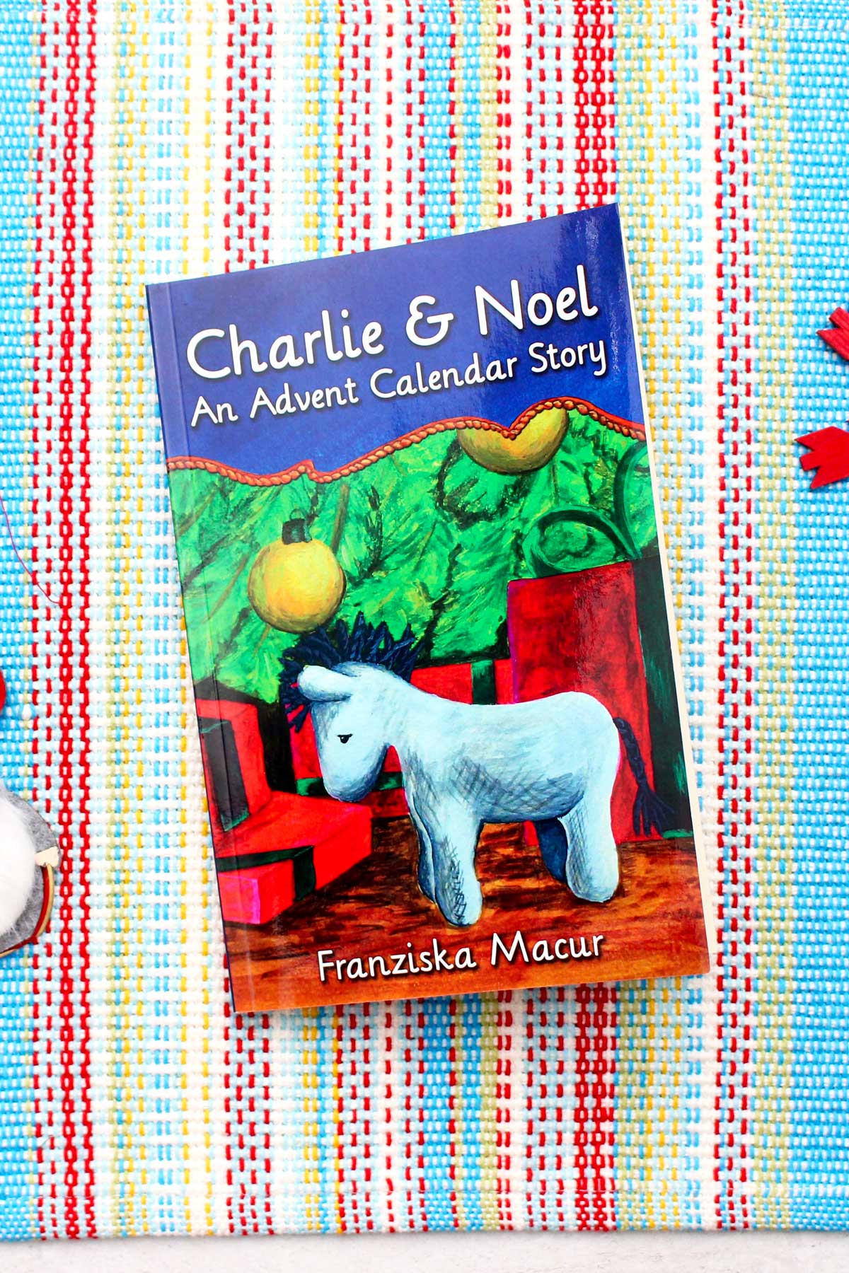 A book called "Charlie & Noel, An Advent Calendar Story" with a picture of a stuffed animal donkey and a Christmas tree on the cover.