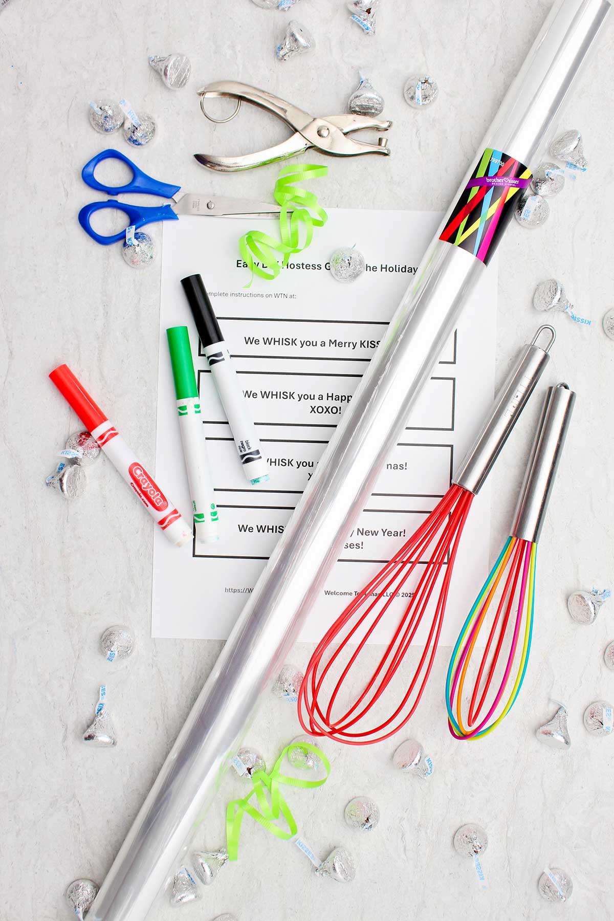 Colorful whisks, cellophane wrapping, markers, scissors, candies and printable notes.