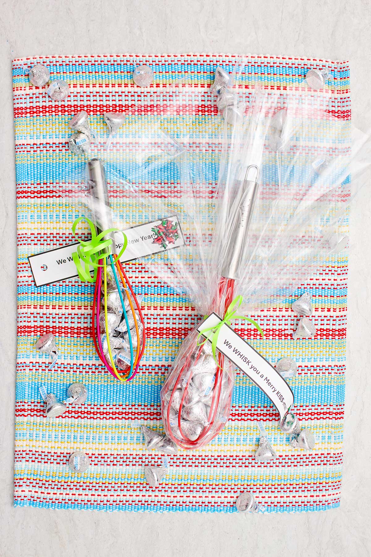 Two completed and wrapped whisk candy gifts wrapped in cellophane with little notes tied on.