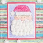 A completed Christmas countdown calendar colored with crayon and Santa's beard covered with cotton balls.