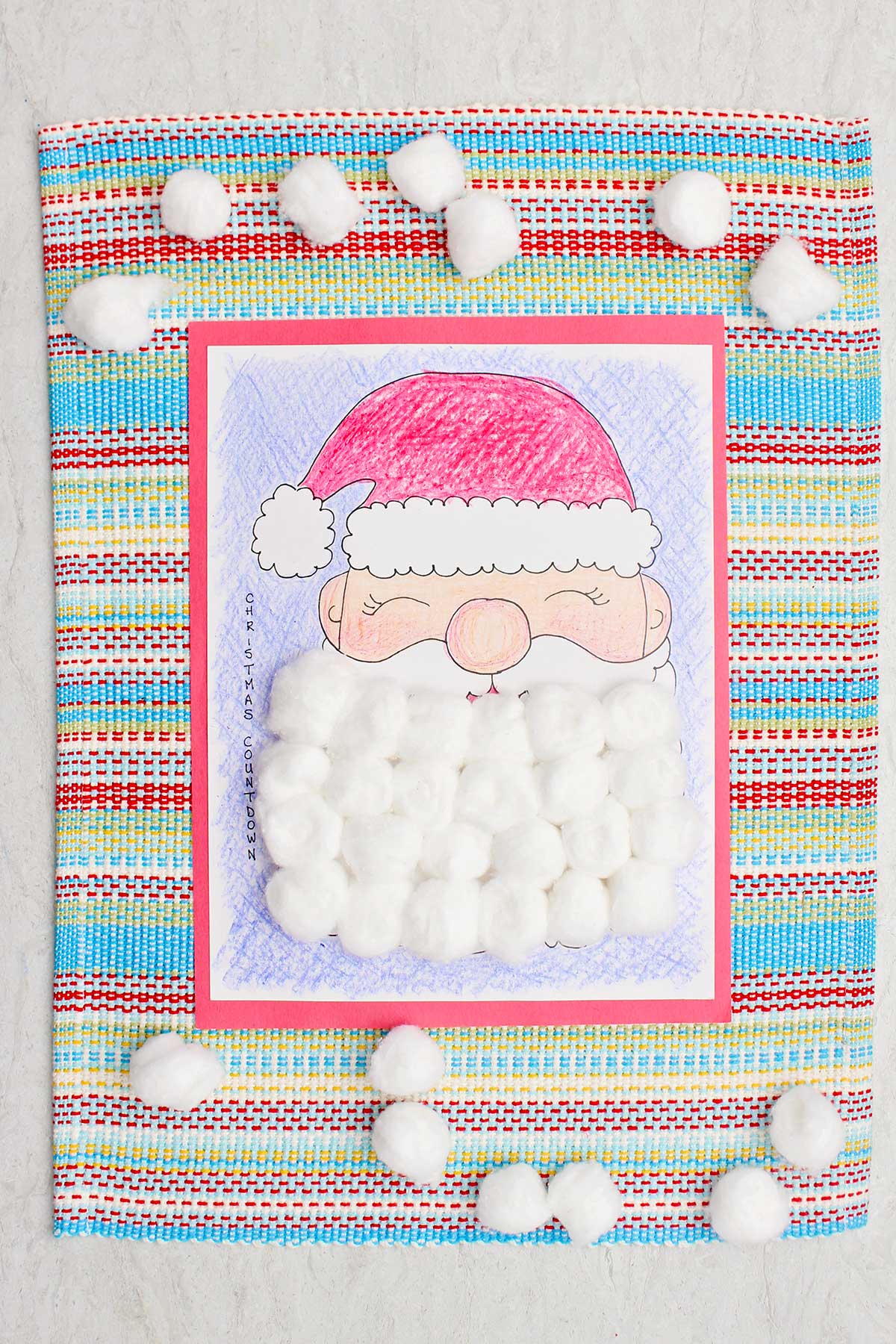 A completed Christmas countdown calendar colored with crayon and Santa's beard covered with cotton balls.