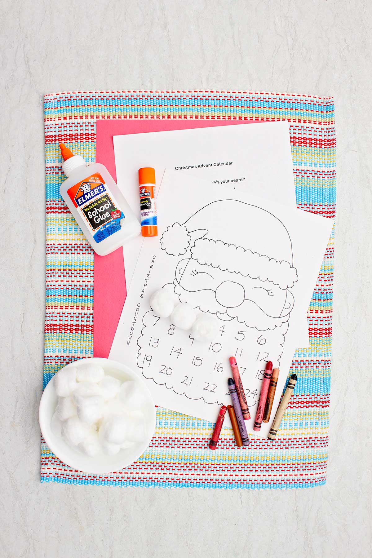 Supplies needed for a Santa calendar countdown. A Santa printable, cotton balls, glue and crayons.