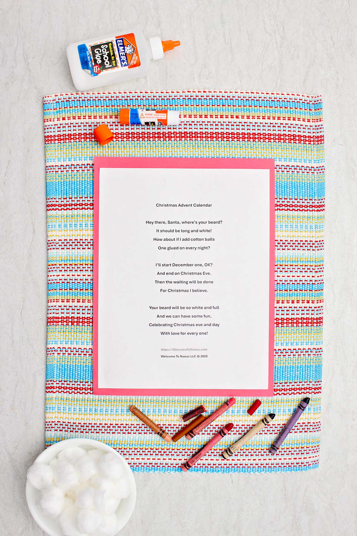 A Christmas Advent Calendar printout on a placemat with crayons, cotton balls and glue near by.