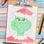 Colored in version of a Grinch sketch with colored pencils near by.