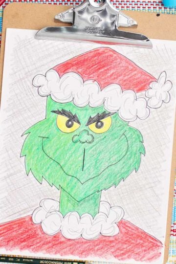 Colored in version of a Grinch sketch with colored pencils near by.