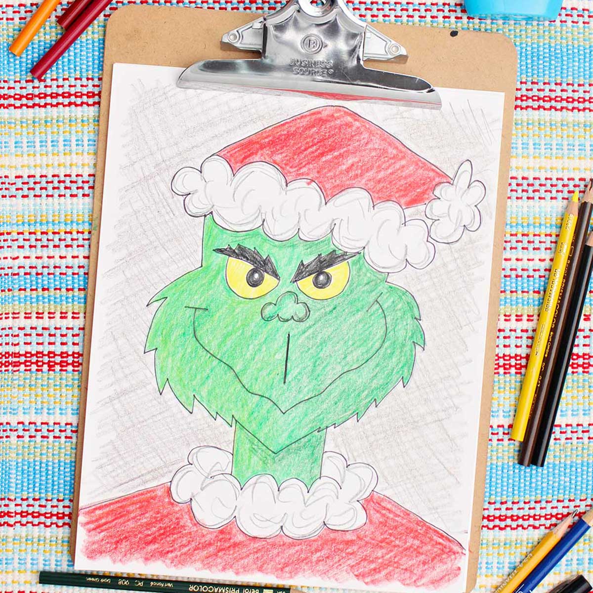 Colored in version of a Grinch sketch with colored pencils near by.