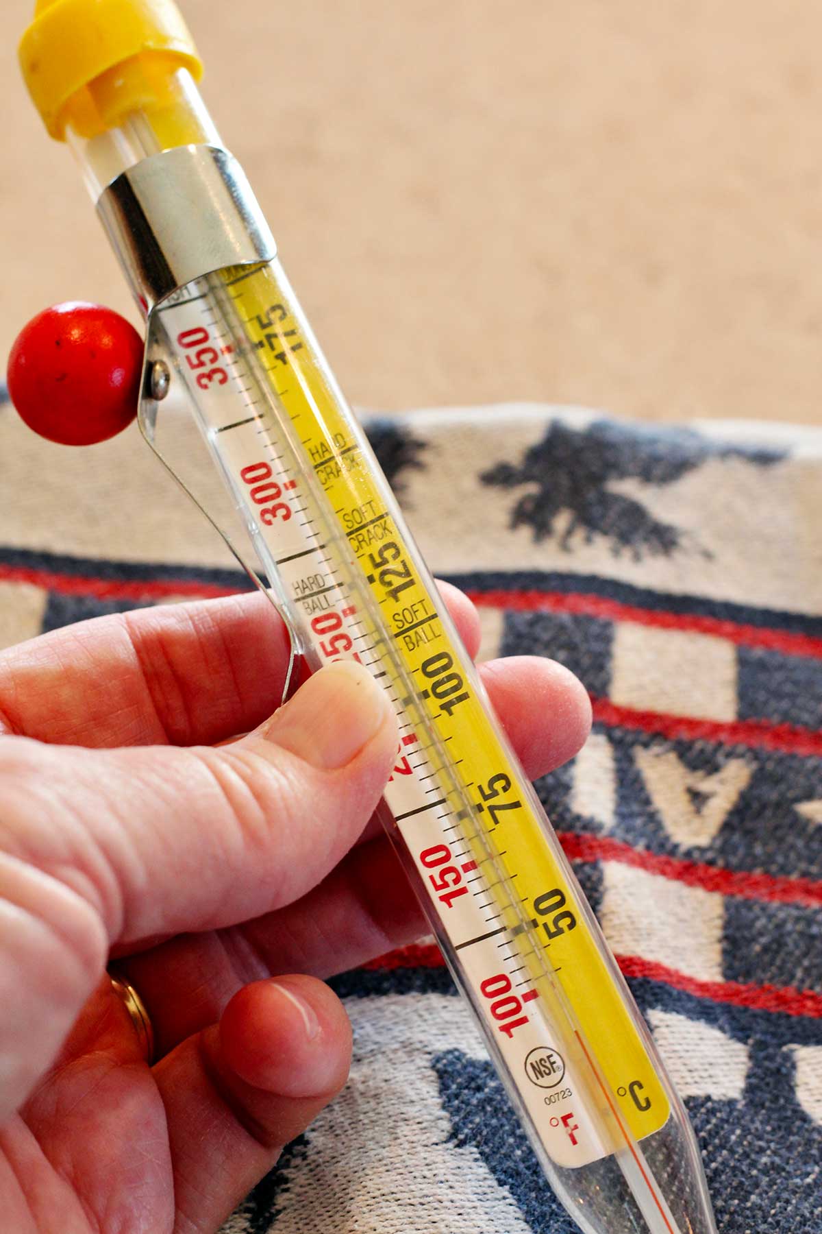 A person holding a candy thermometer.