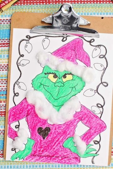 Completed Grinch colored printable complete with cotton ball accents clipped into a clip board.
