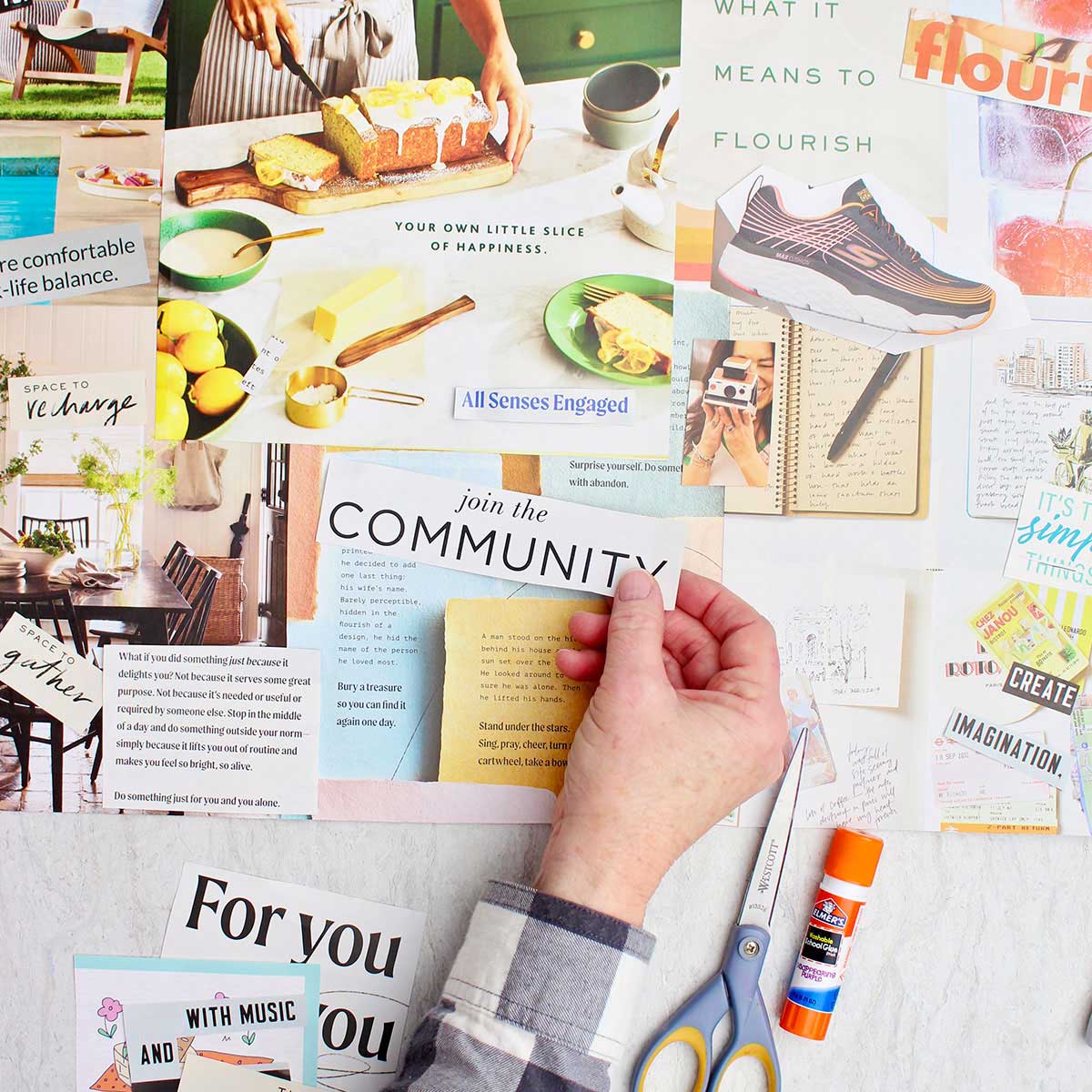 A person sticking a magazine cut out that says "join the community" on their vision board.