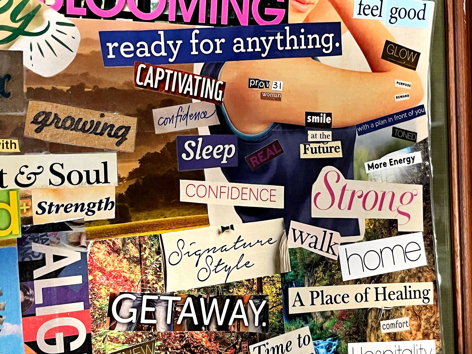 A close up of a magazine clipping vision board with bold text and bright colorful pictures.