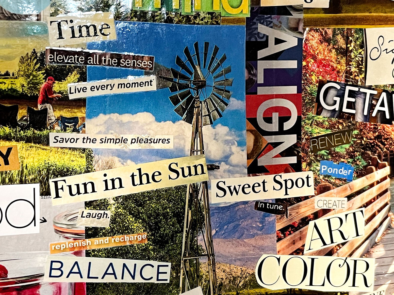A close up of a magazine clipping vision board with bold text and bright colorful pictures.