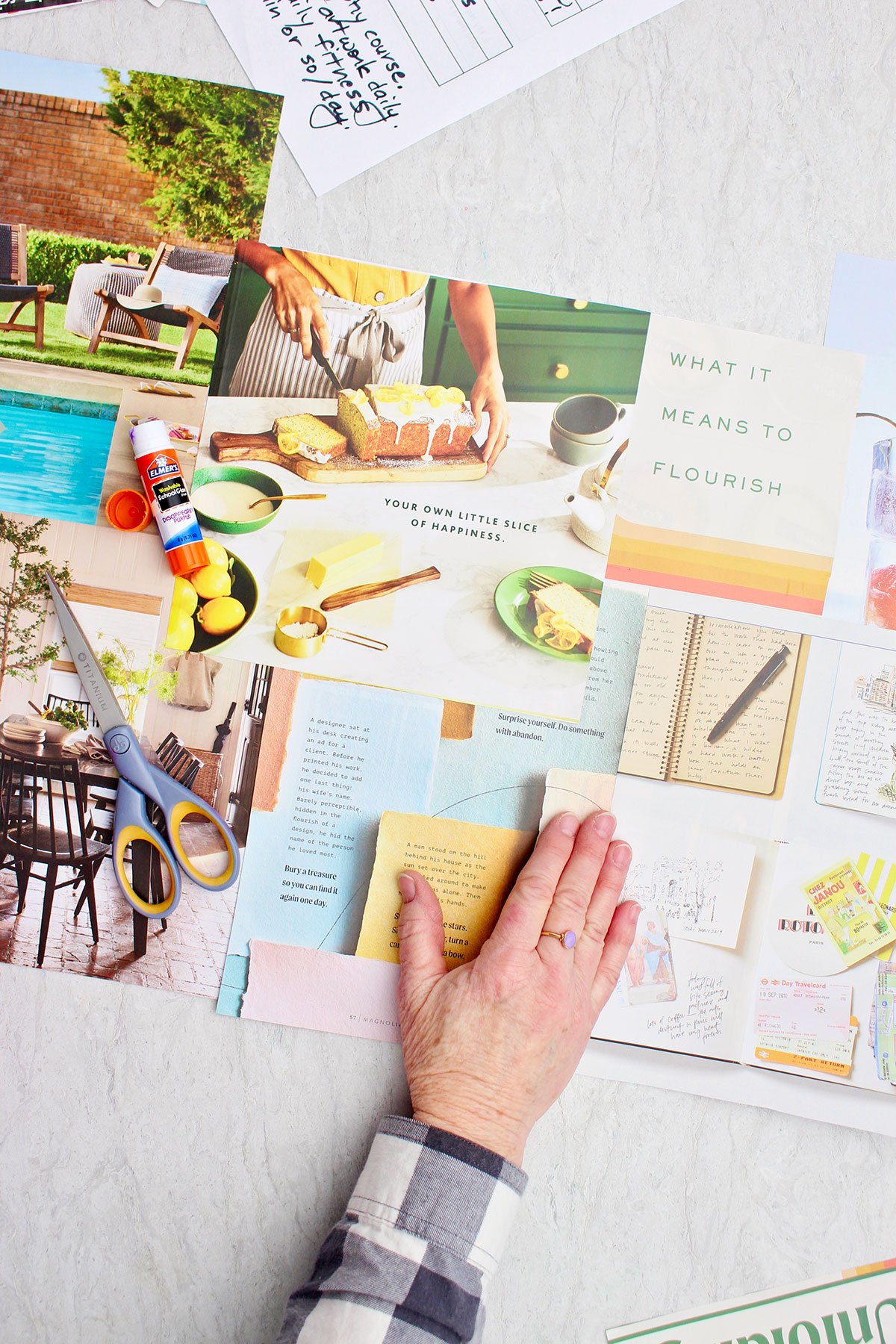 A person laying out some ideas and magazine cut outs for their vision board.