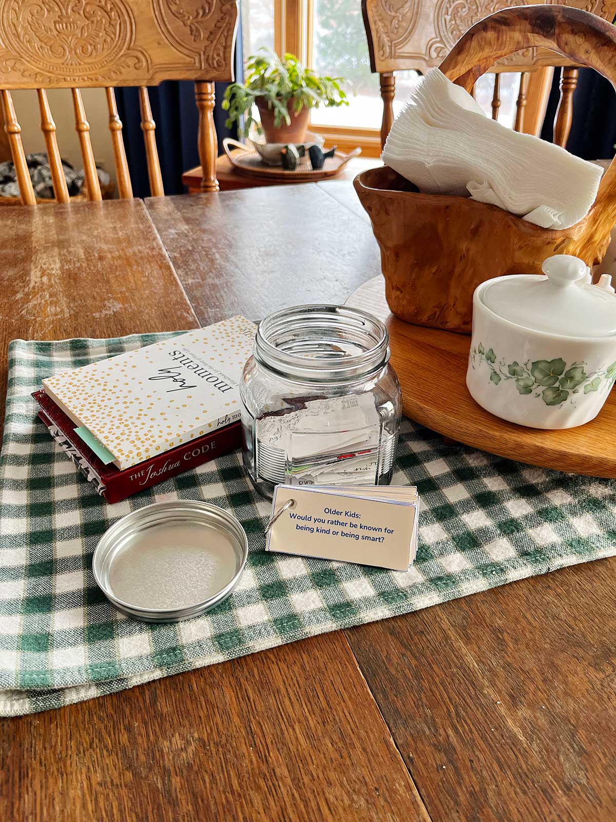 A stack of Would You Rather questions sitting next to a jar on a table.