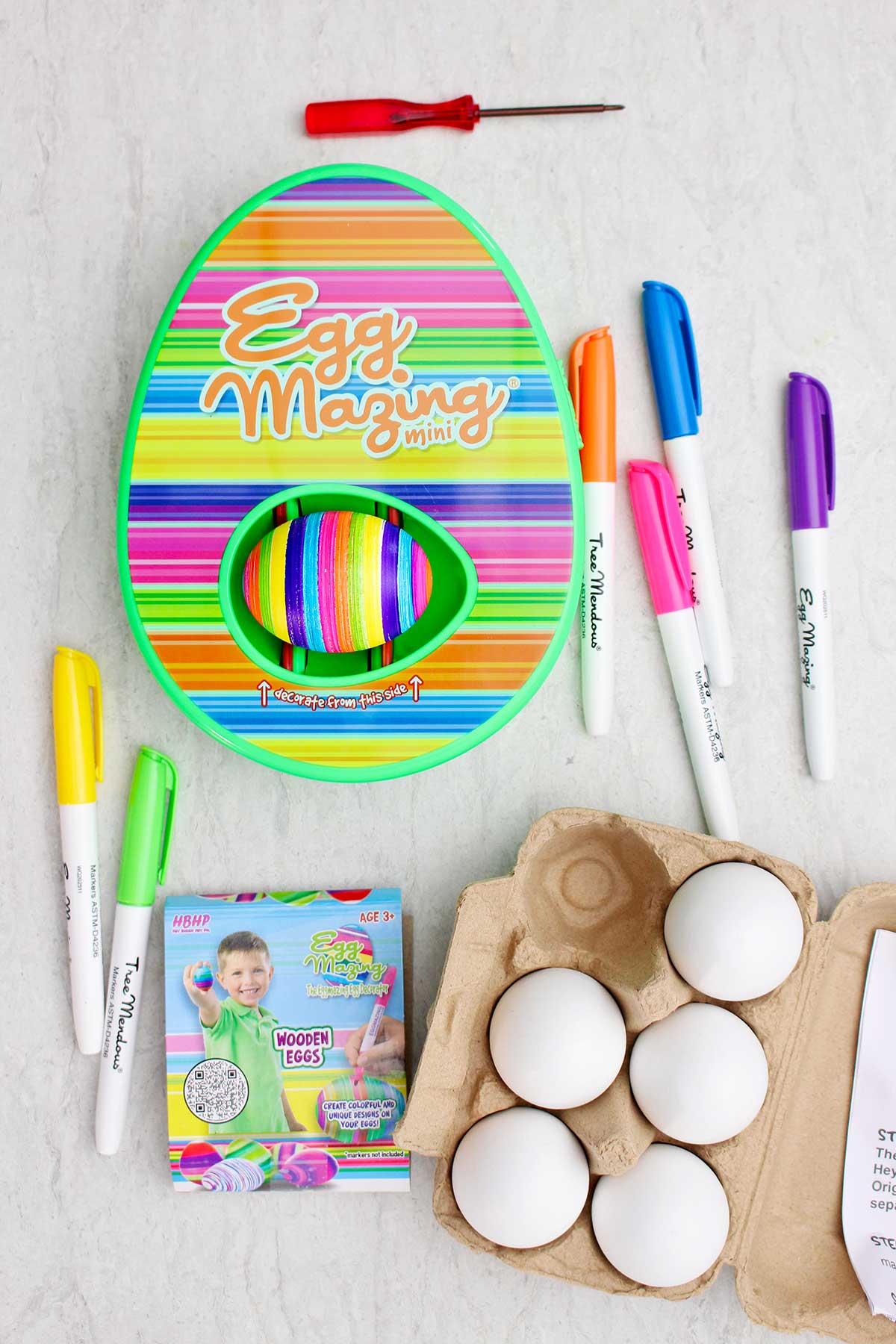 The striped EggMazing kit complete with markers, wooden eggs and eggs in an egg carton.