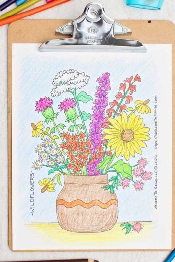 A coloring page of a brown vase full of colorful wildflowers clipped on a clipboard with colored pencils scattered around.
