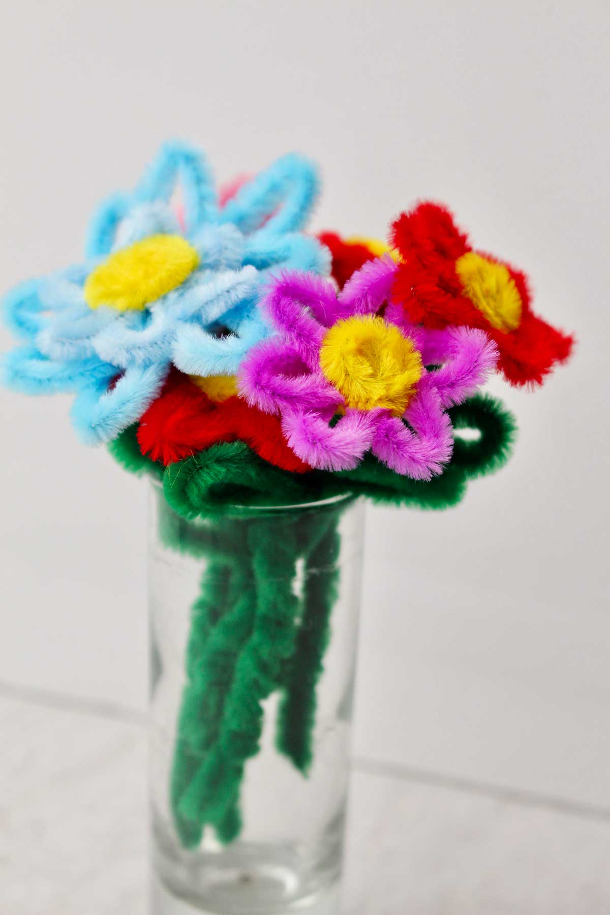 A pipe cleaner flower bouquet in a glass.