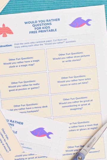 A printable with Would You Rather Questions near a pair of scissors