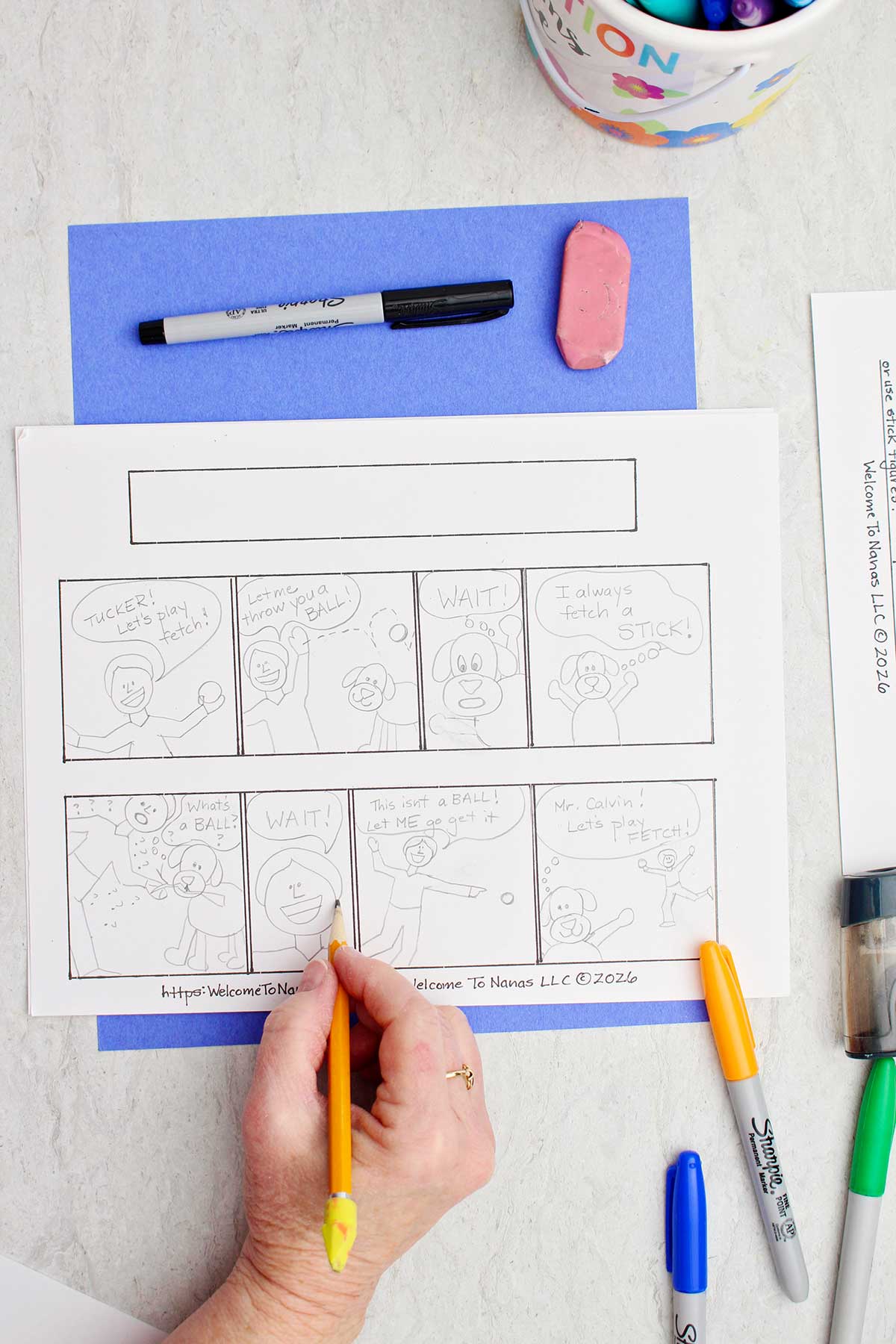 A person sketching out a story on their comic strip with pencil.