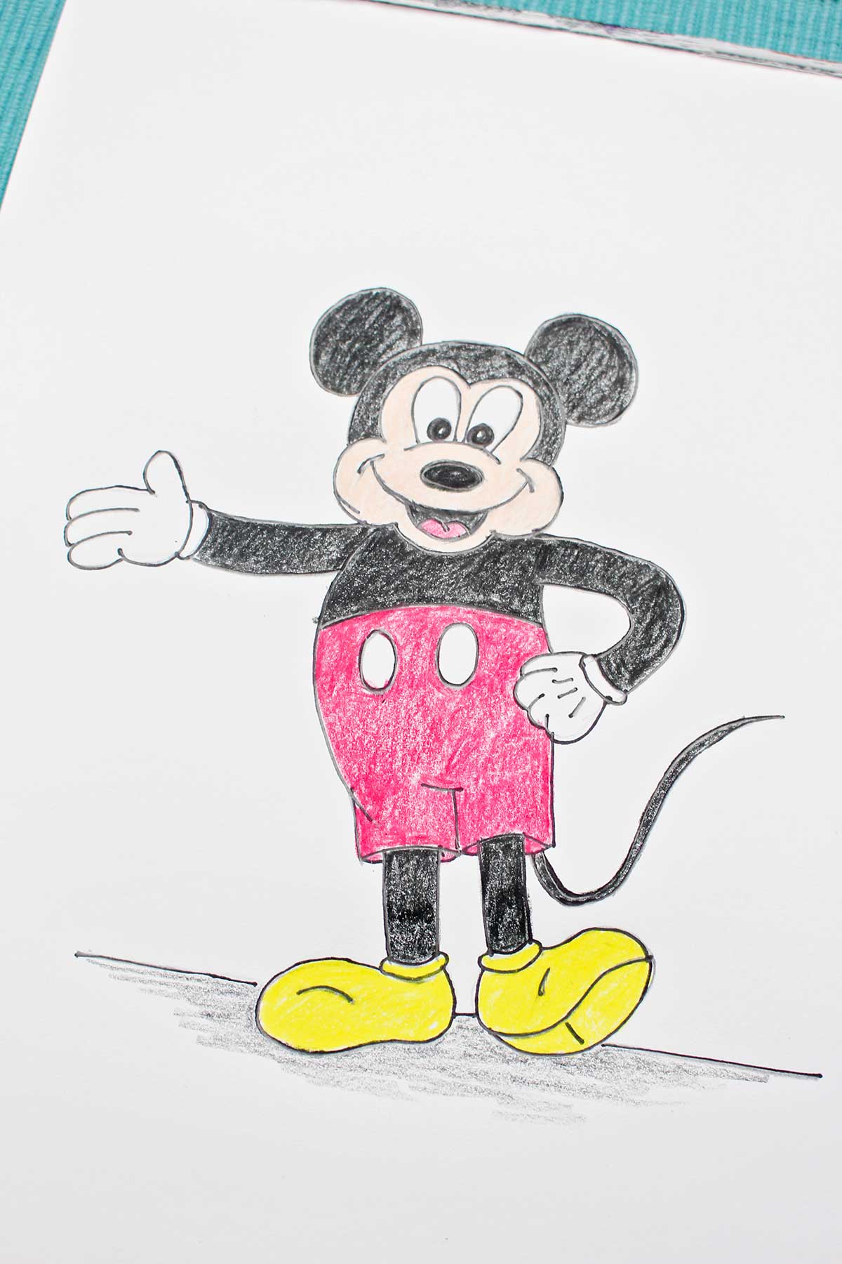 A completed and colored sketch of Mickey Mouse with his hand on his hip and his other arm out.