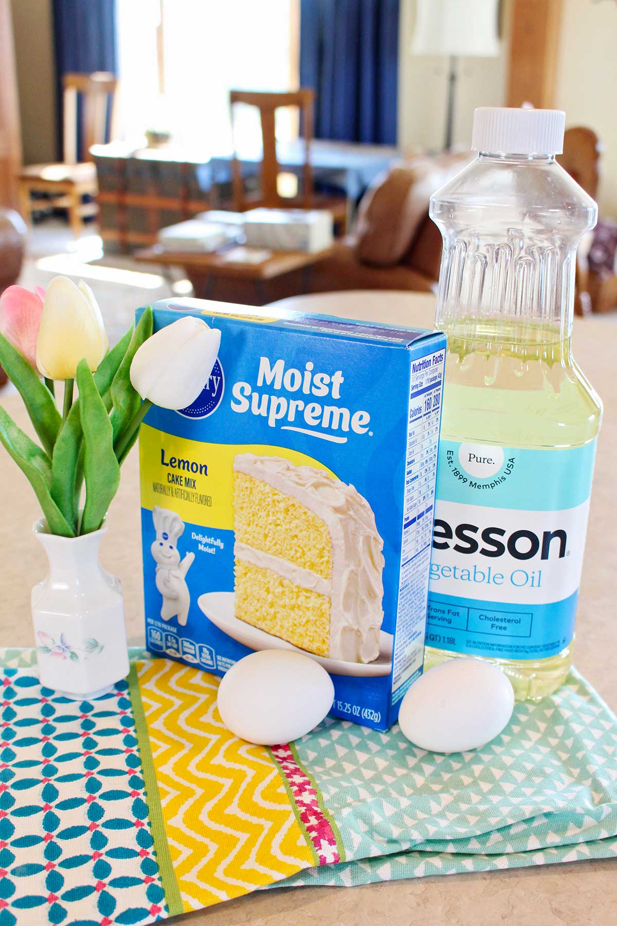 Supplies to make lemon cake mix cookies sitting on a colorful hand towel on the counter.