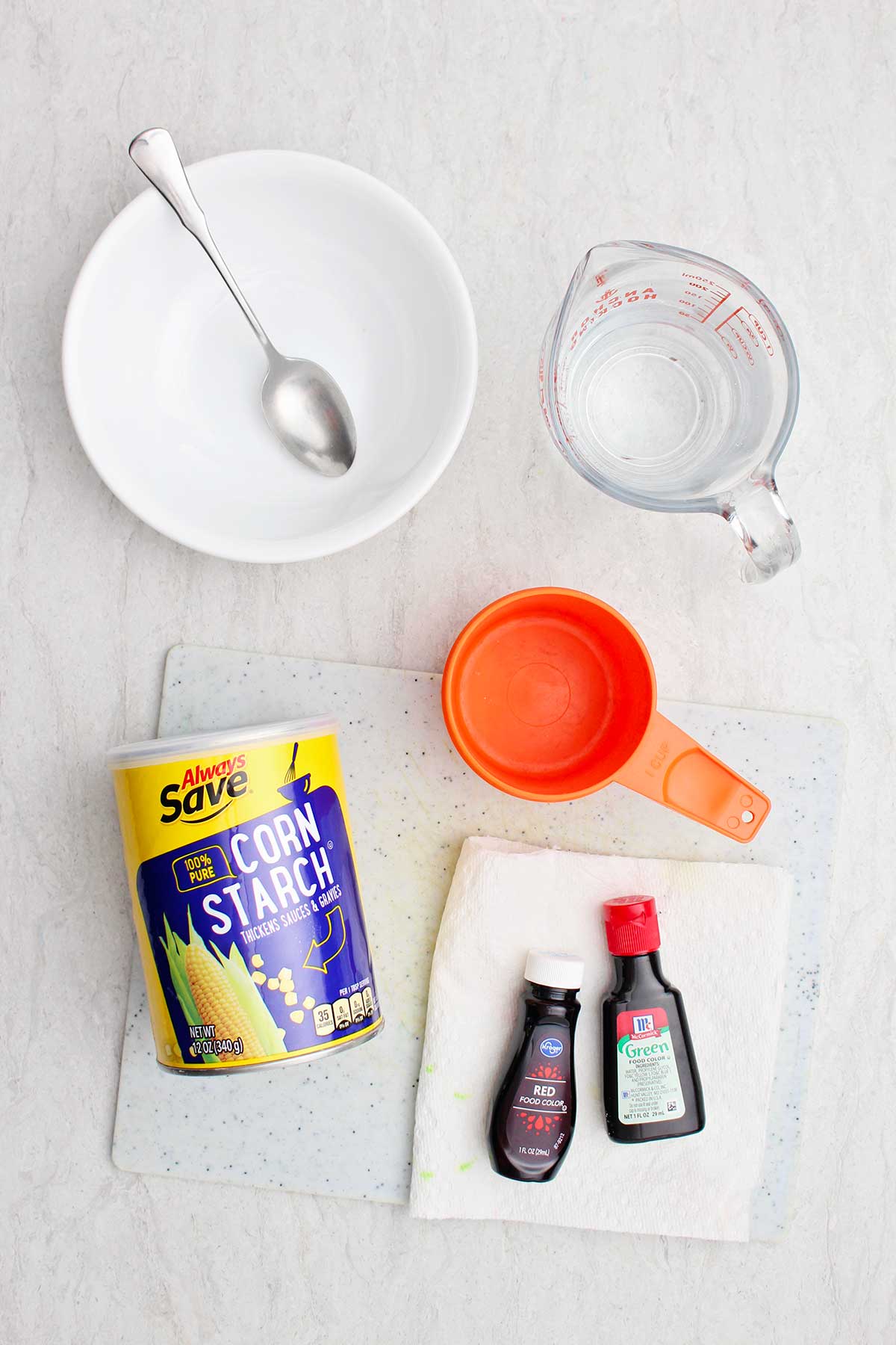 Ingredients for oobleck. Cornstarch, water and food coloring with other kitchenware for creating oobleck.