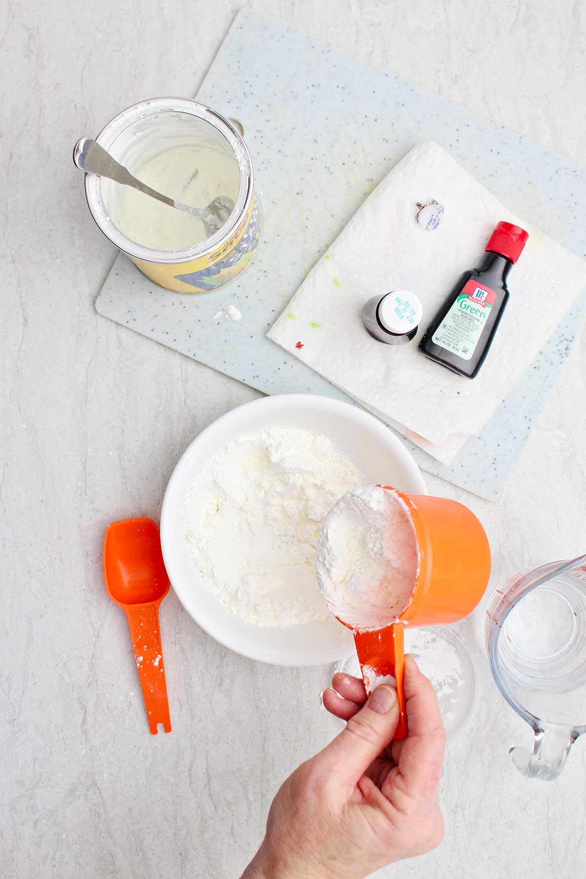 A person measuring out some cornstarch into a bowl.