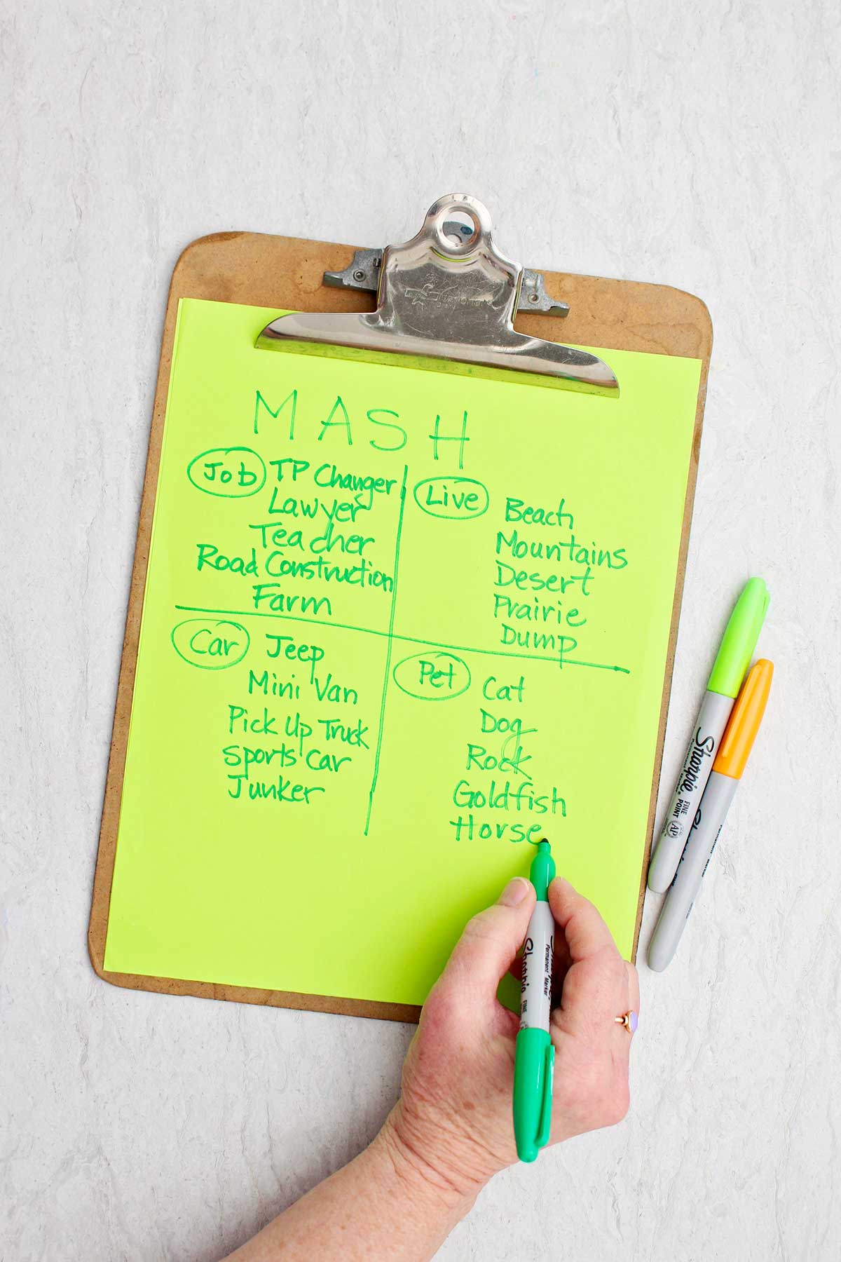 A person writing down pet options for that category in a MASH game.