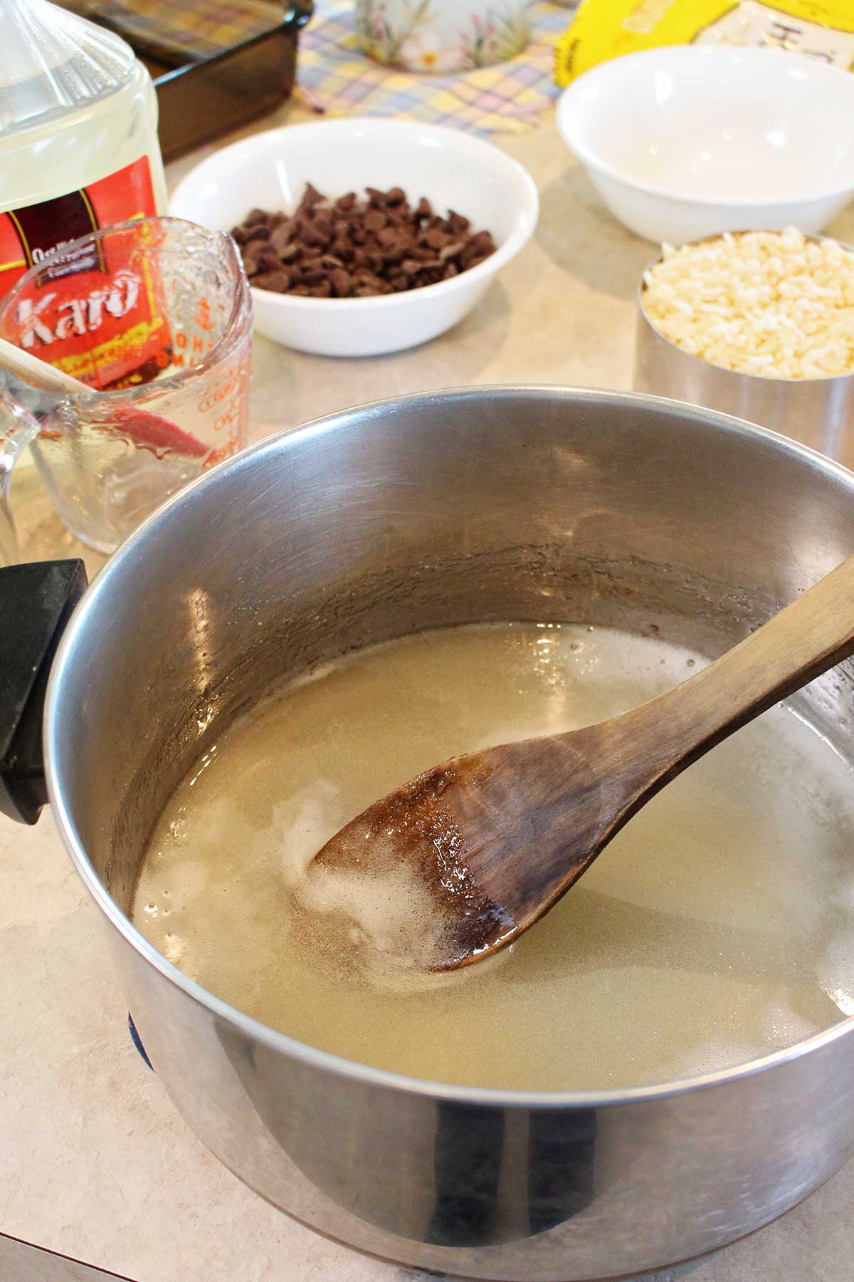 Karo syrup mixture in a pot with other ingredients near by.
