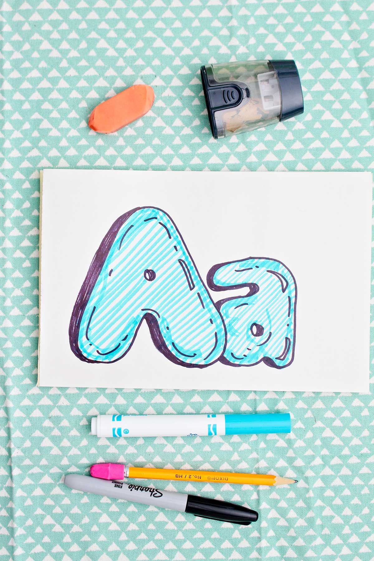 Bubble letter "A" in upper and lowercase shadowed in sharpie and colored in with blue marker lines.