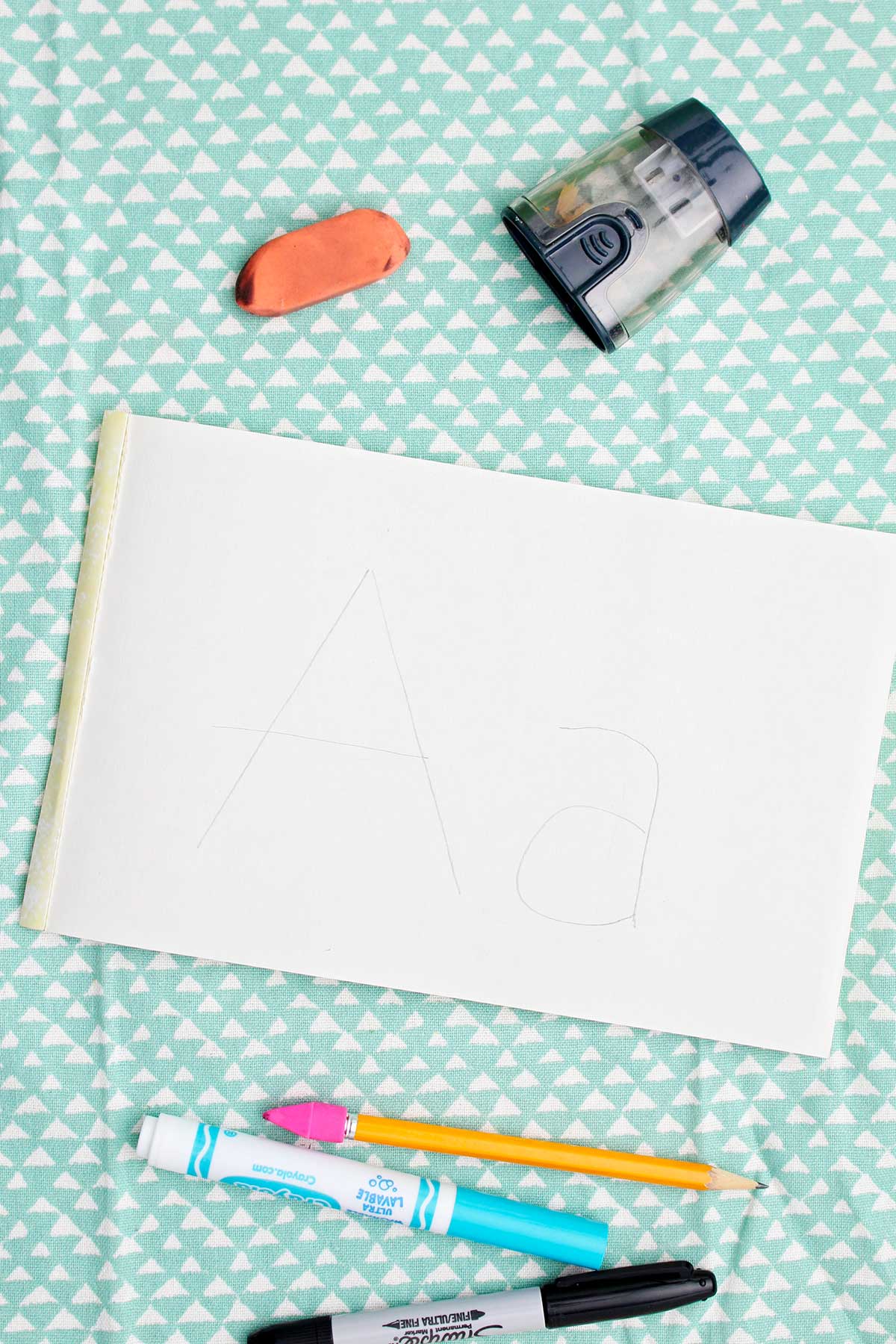 An upper and lowercase a sketched on a white piece of paper.